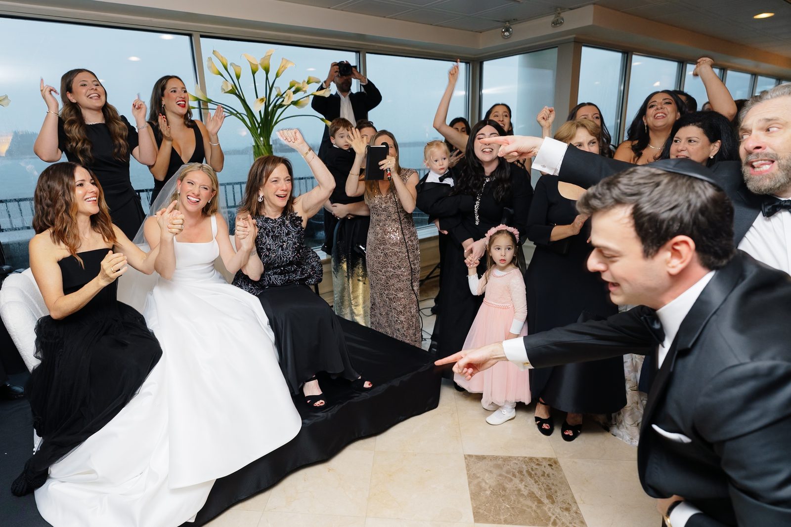 David arriving for the bedeken as Hana laughs, surrounded by guests