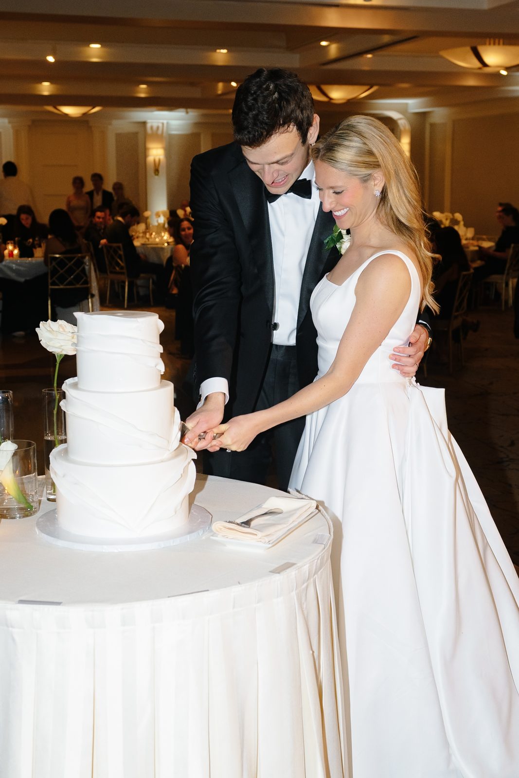 Hana and David cutting their white wedding cake