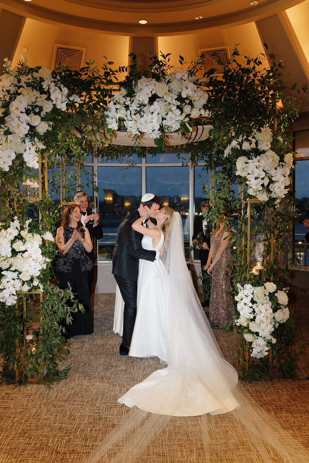 Hana and David kissing under the chuppah after the ceremony