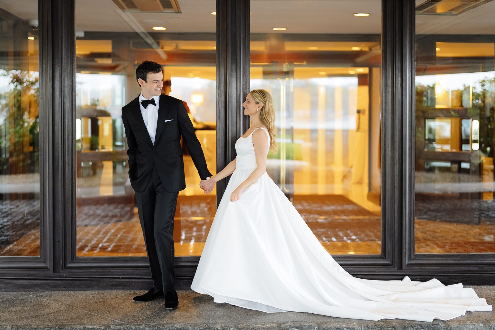 Wide portrait of Hana and David at the glass doors of Glen Island Harbour Club