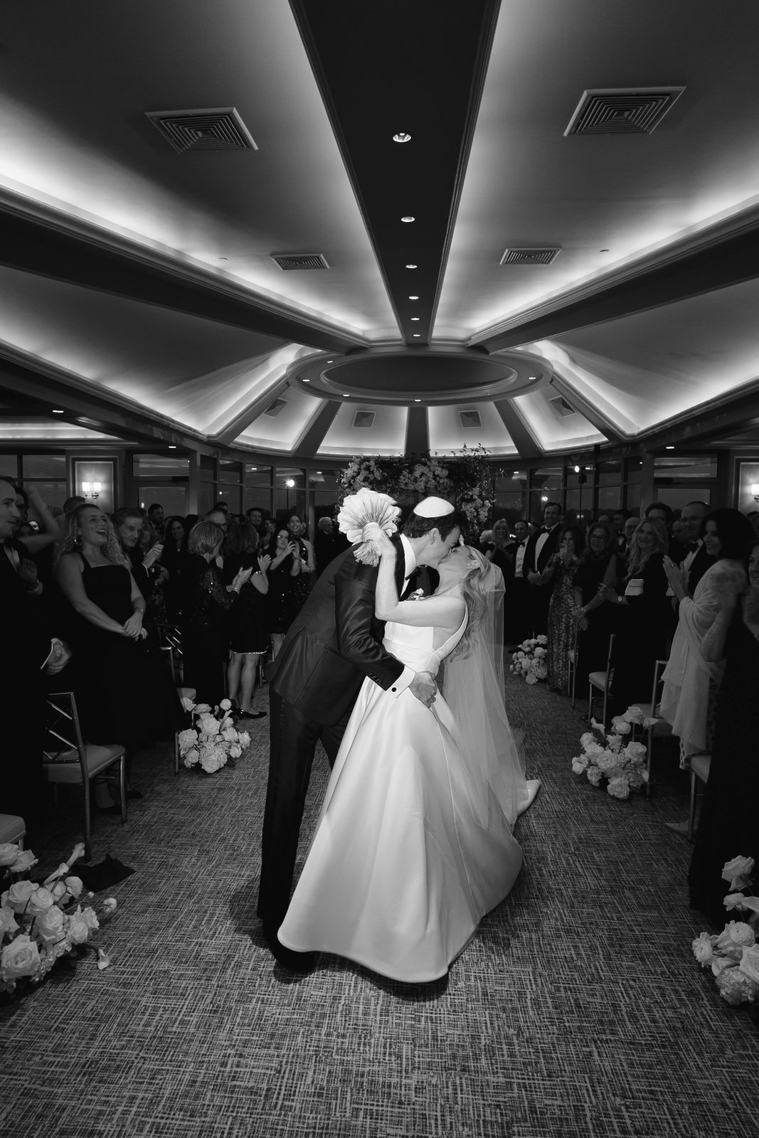 Black and white of Hana and David kissing on the aisle at Glen Island Harbour Club