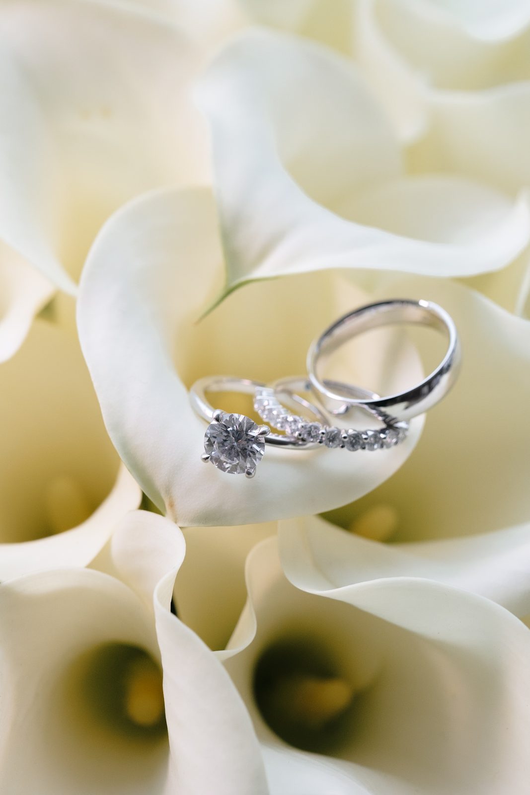 Wedding rings resting in white calla lilies