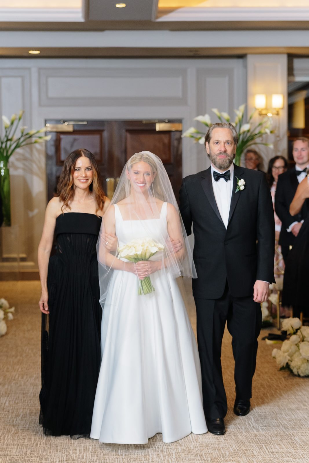 Hana walking down the aisle with her parents at Glen Island Harbour Club
