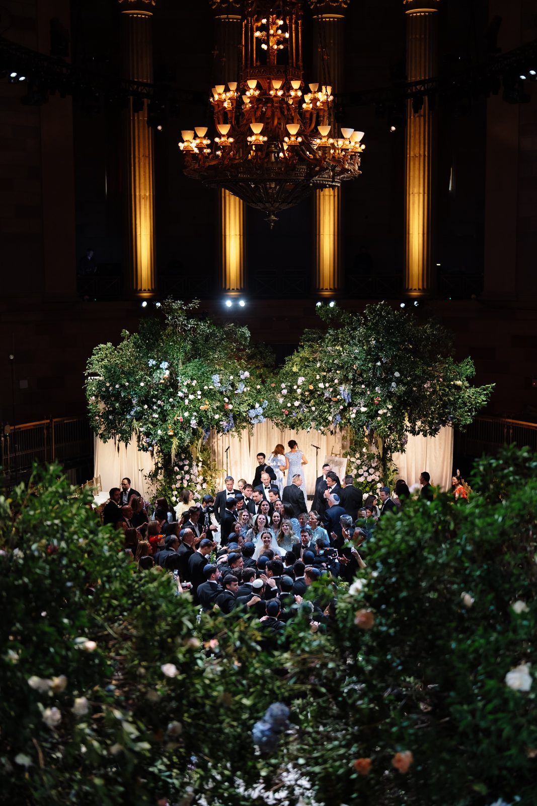 The Gotham Hall ceremony seen from above, the chuppah ringed with greenery and guests