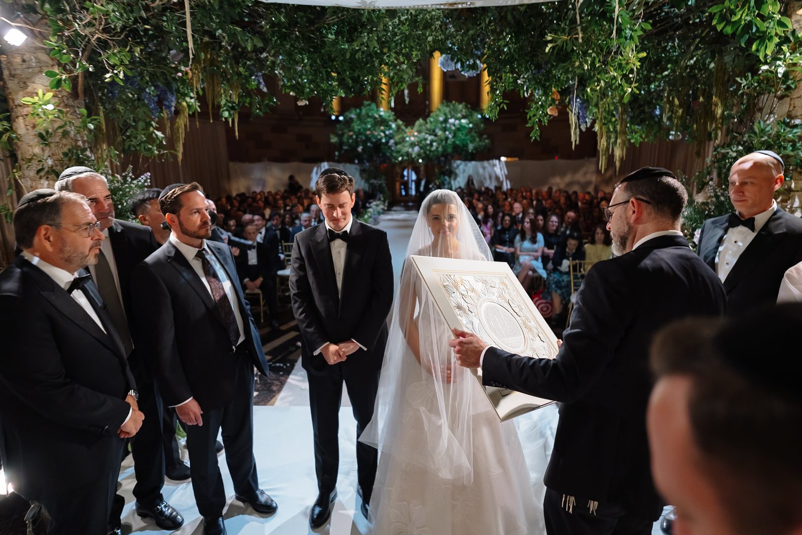 Jessie and Linus under the chuppah at Gotham Hall as the ketubah is presented