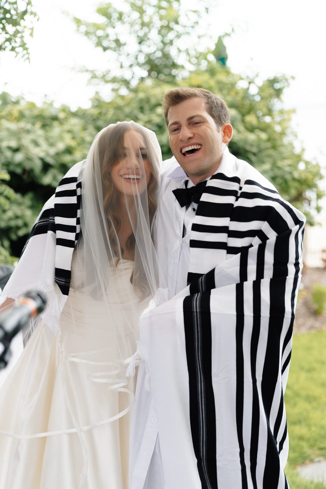 Jon in his tallit, laughing with Maayan at the bedeken