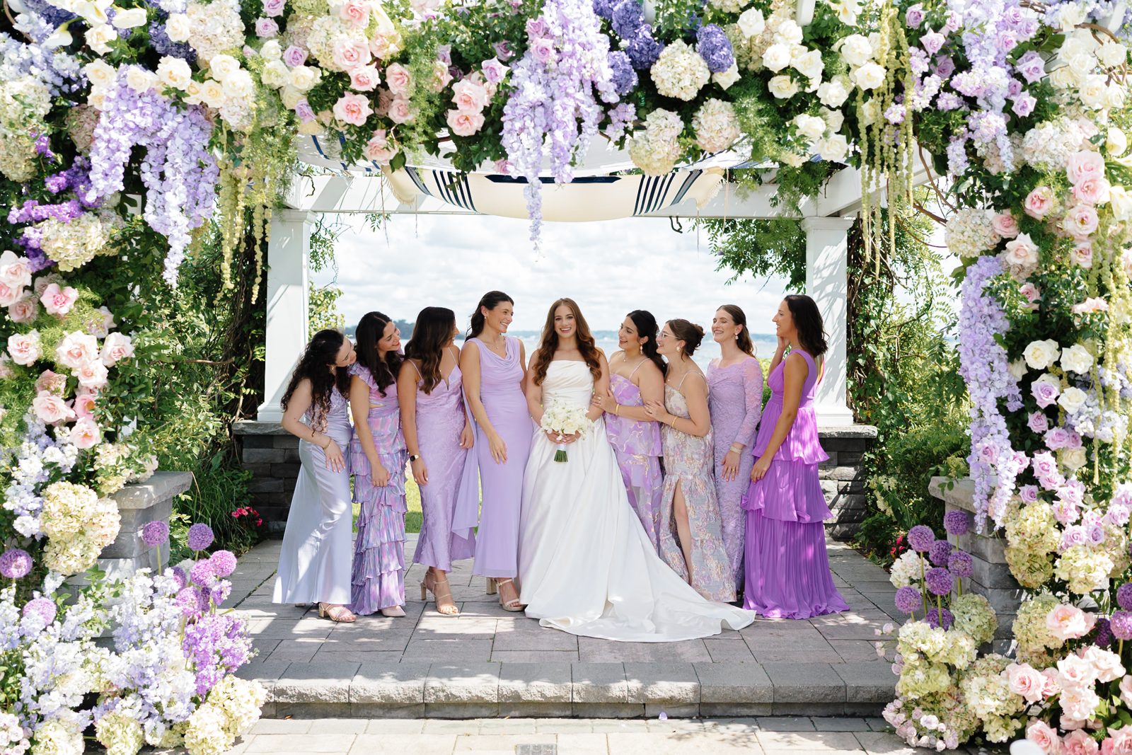 Bridesmaids in lavender beneath the floral chuppah at Greentree Country Club, New Rochelle NY