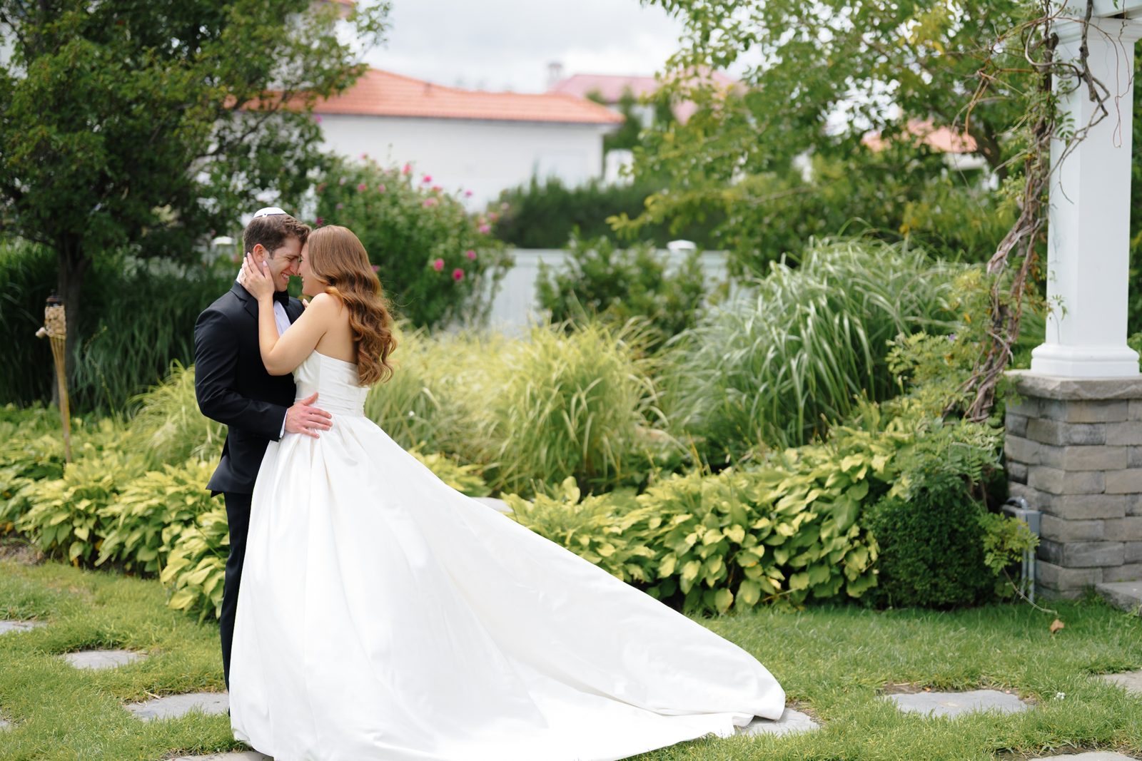 The first look embrace in the gardens at Greentree Country Club