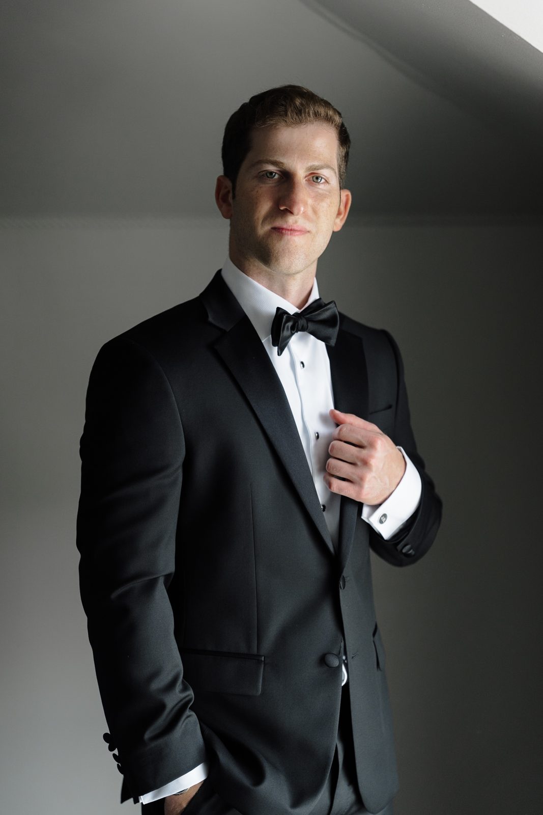 Groom&rsquo;s portrait in window light at Greentree Country Club, New Rochelle NY