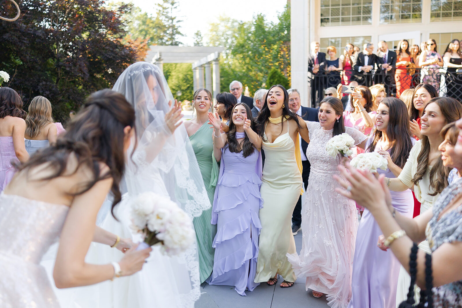 Noa’s bridesmaids celebrate around her at the bedeken