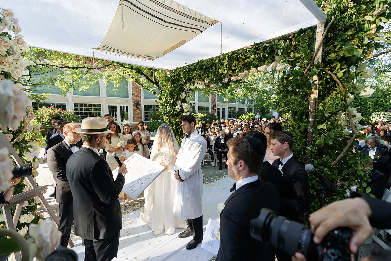 The chuppah ceremony in the garden under a white canopy