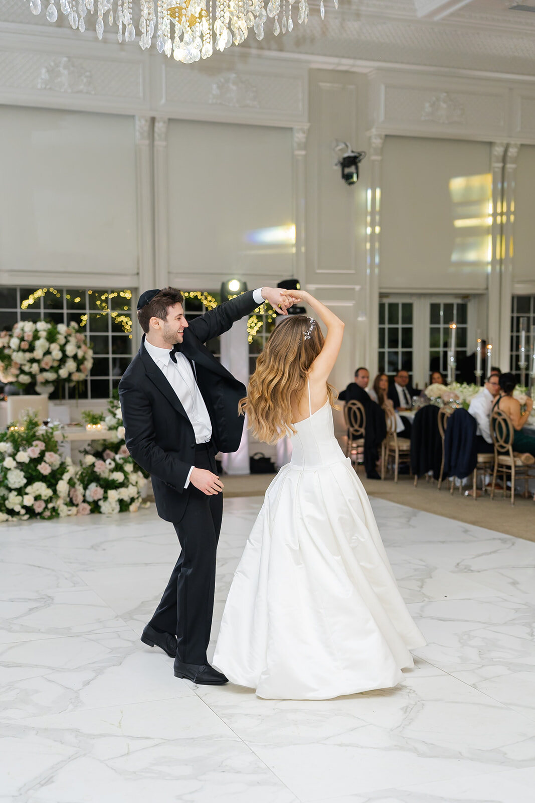 Noa and Nate share their first dance in the white ballroom