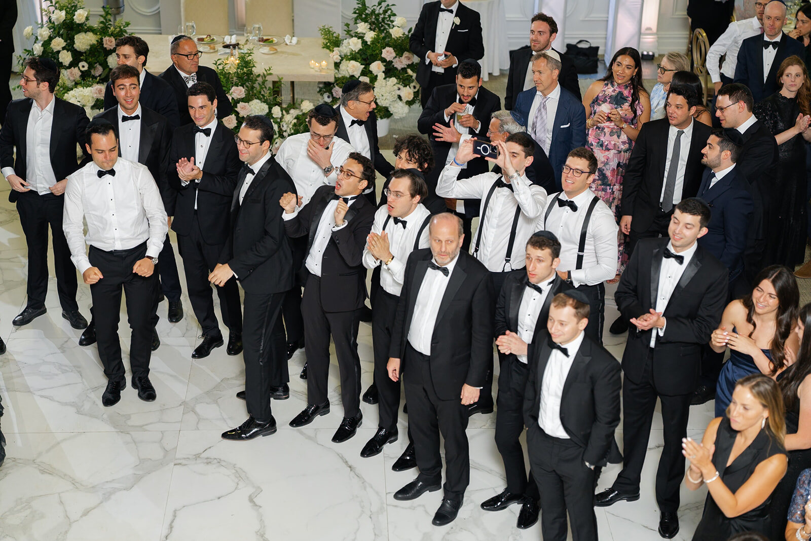 Nate’s groomsmen dance in a line across the ballroom floor