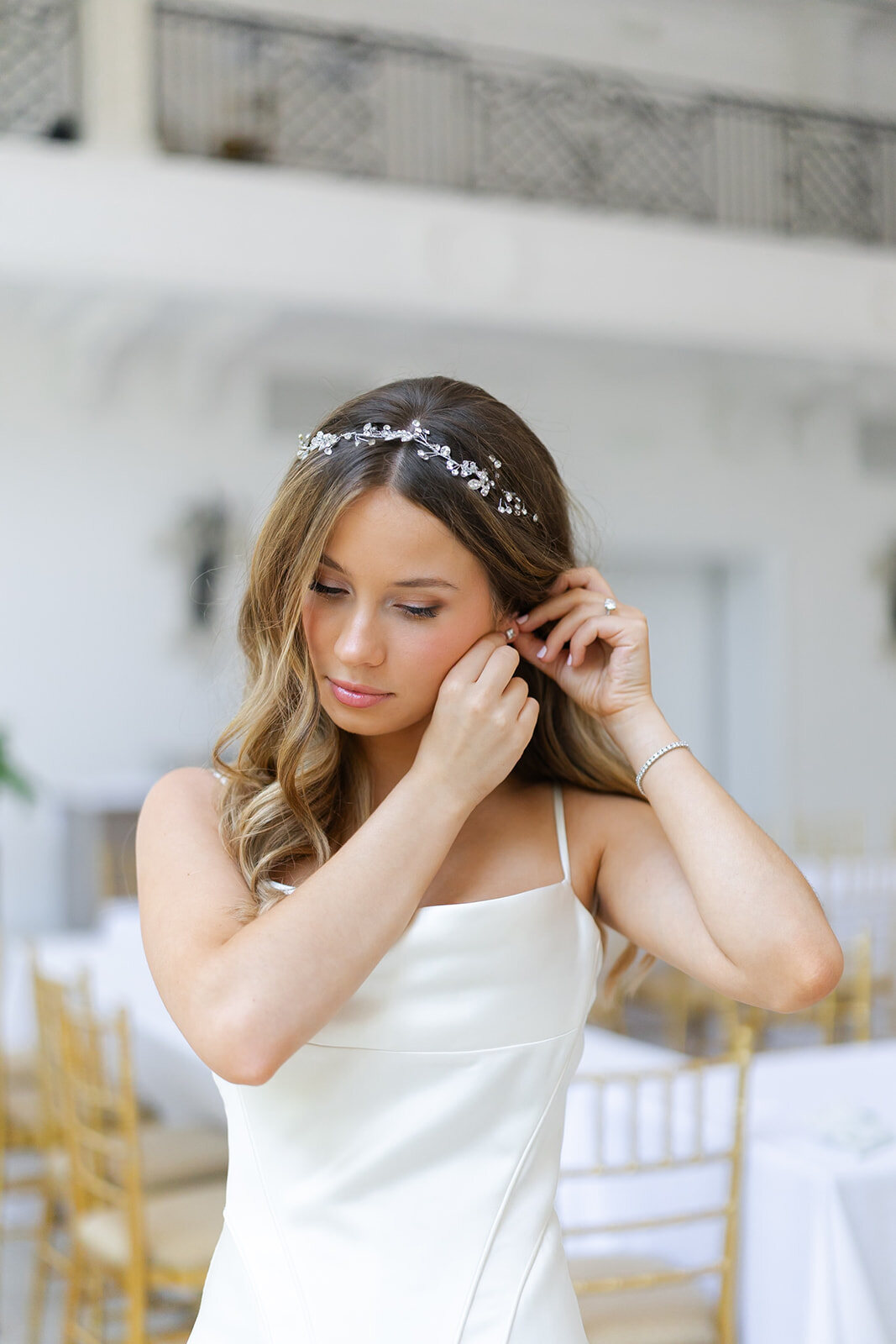 Noa adjusts her earring, a delicate hair vine in her hair