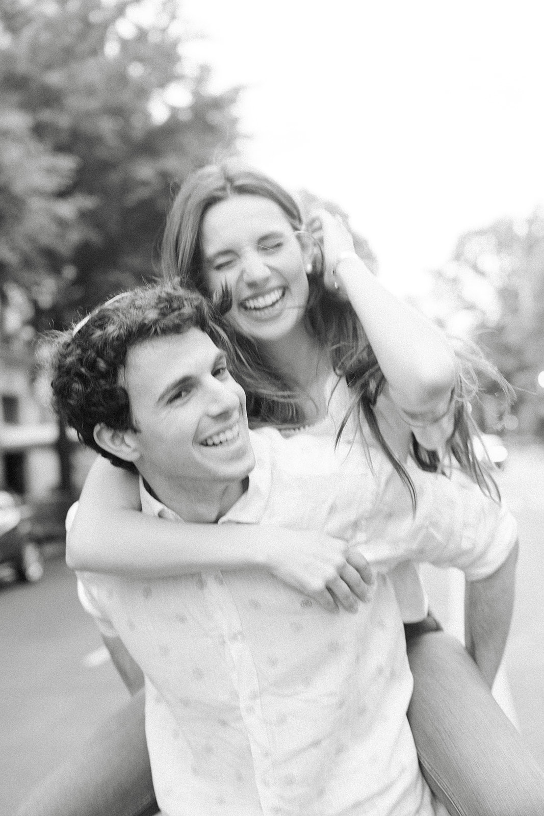 A playful piggyback moment on a cobblestone street during a downtown Manhattan engagement session.