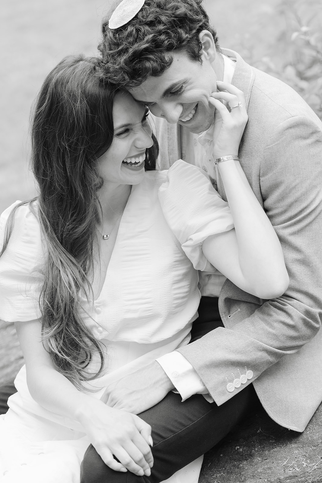 Black and white photo of a couple laughing together during their West Village engagement session.