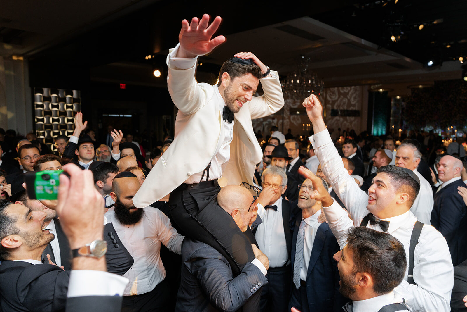 Aaron lifted on a chair during the hora at Old Westbury Hebrew Congregation