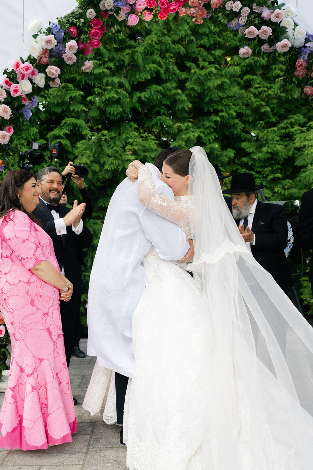 Arielle and Aaron kiss on the recessional as guests cheer at Old Westbury Hebrew Congregation