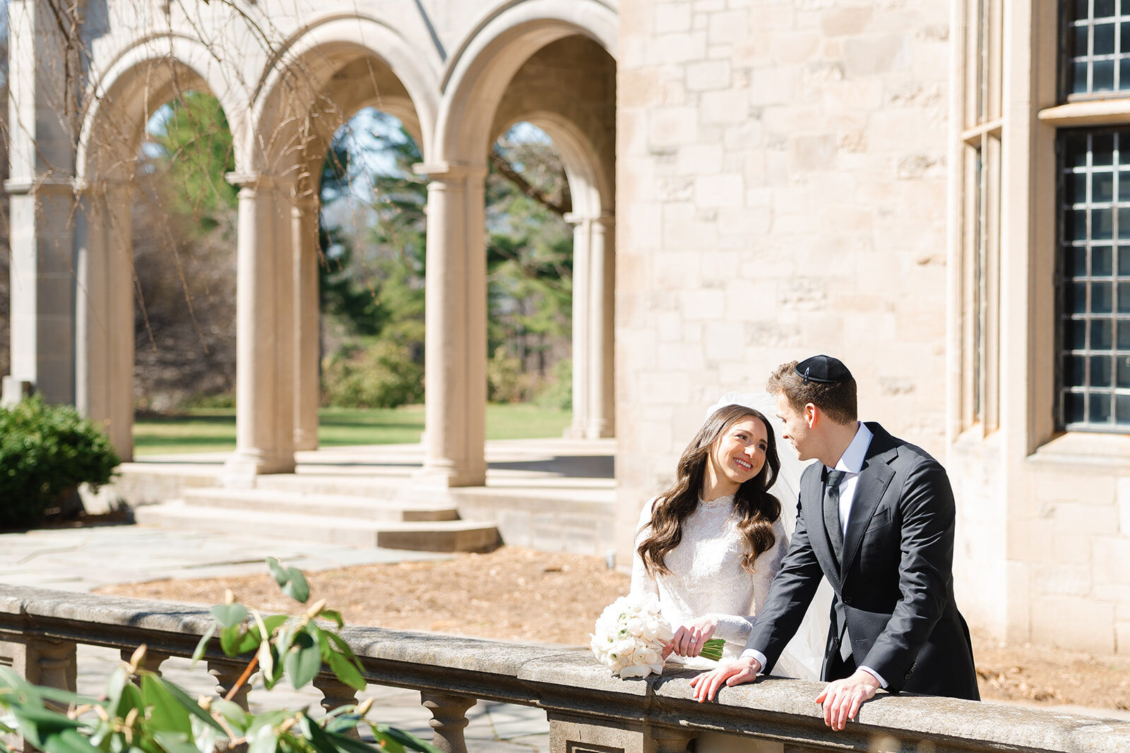 Kelly and Jacob on a stone terrace beneath an arcade of arches during portraits
