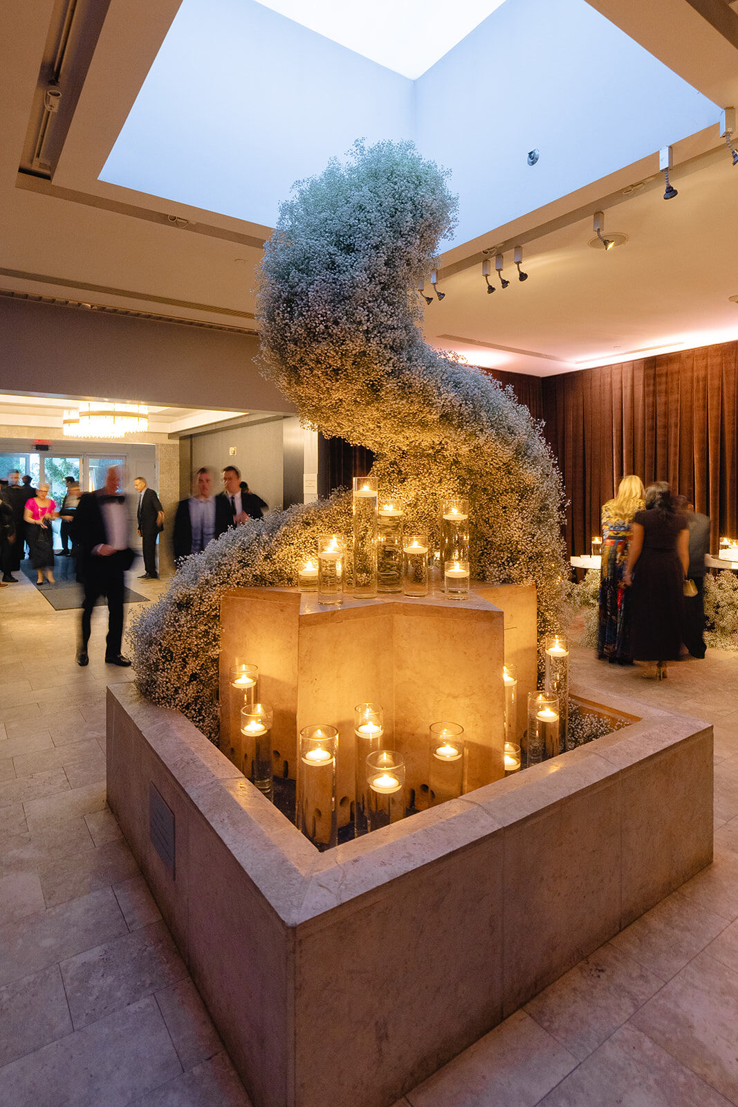 Cocktail lounge at Old Westbury Hebrew Congregation with a sculptural white floral installation and candles