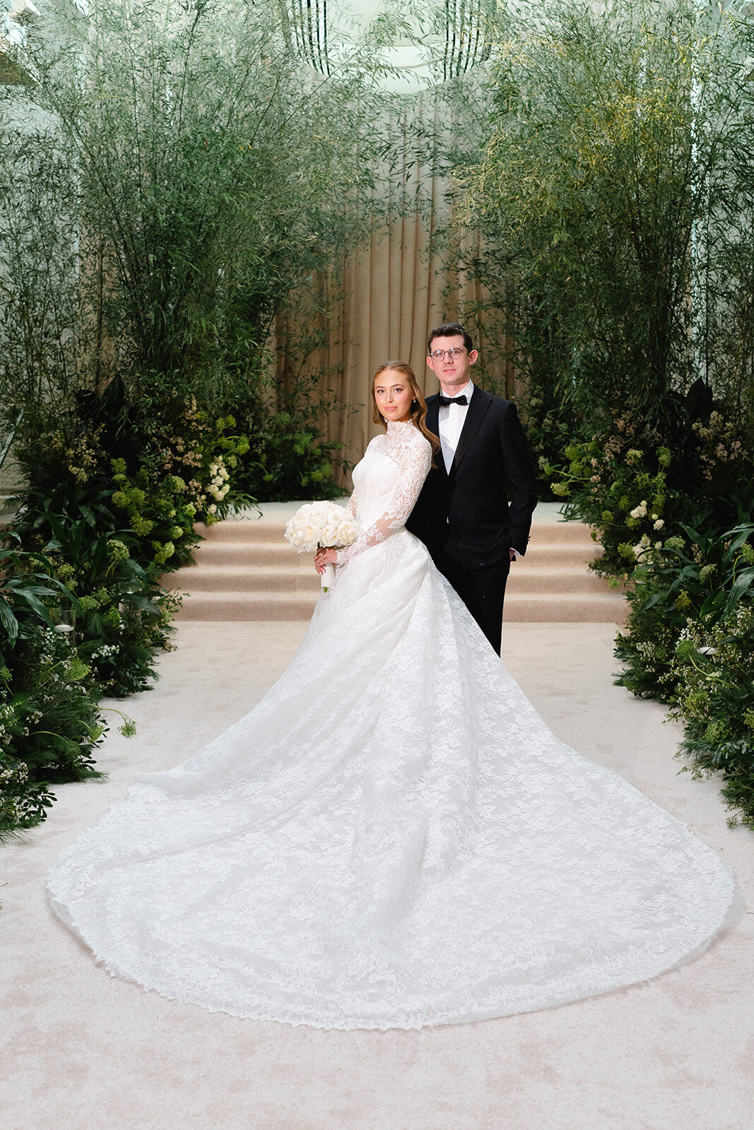 Rebecca and Joe in front of the living greenery wall in the ballroom at Old Westbury Hebrew Congregation