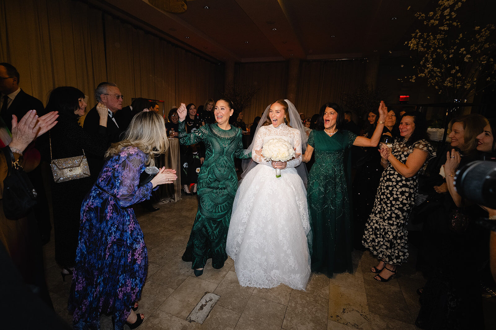 Rebecca is veiled by Joe at the bedeken at Old Westbury Hebrew Congregation, family in emerald green around her