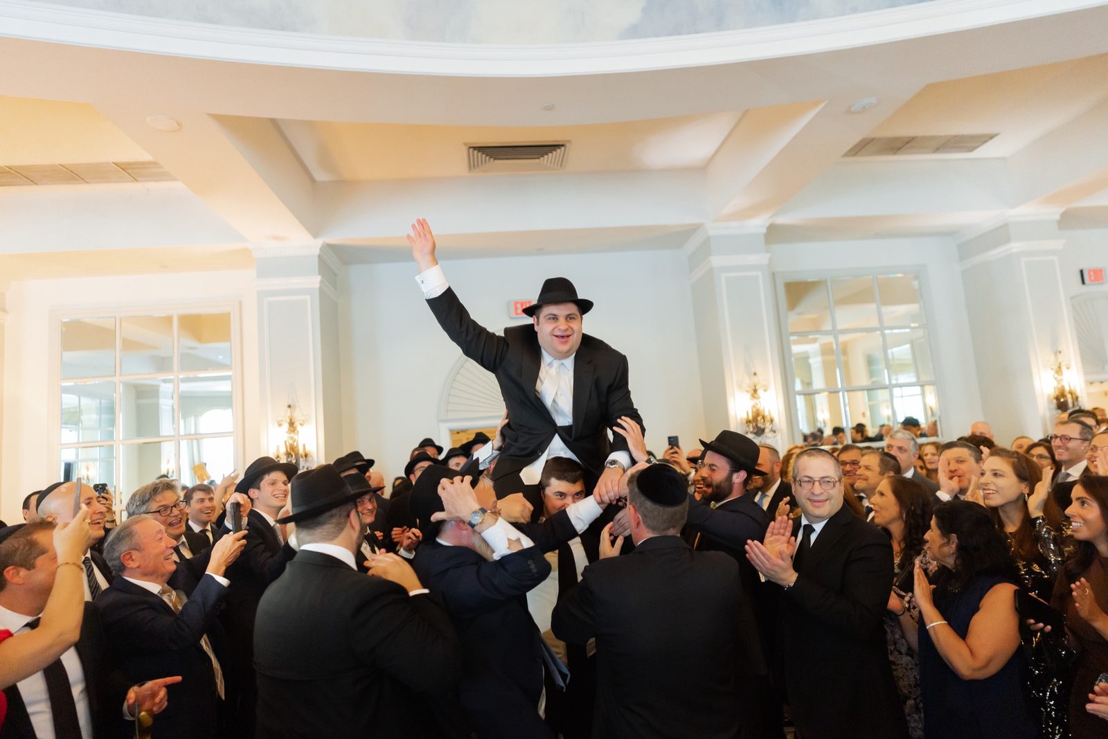 Ezra lifted onto his friends’ shoulders