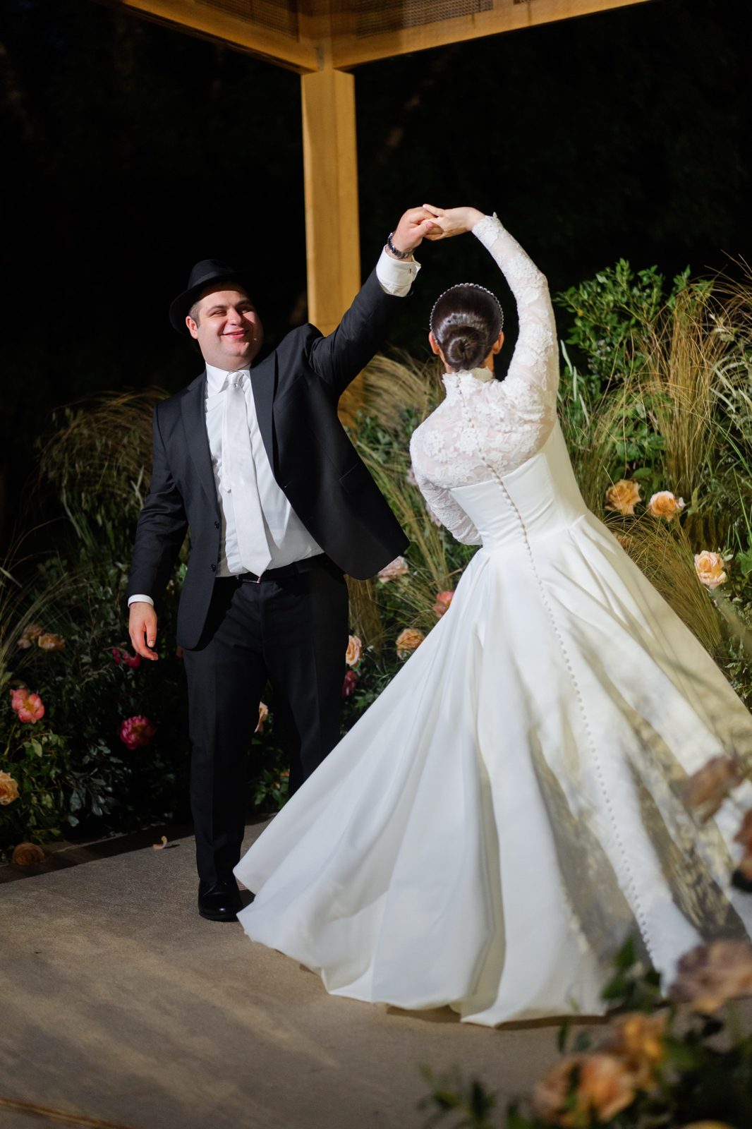 Ezra spinning Goldie under the chuppah at night