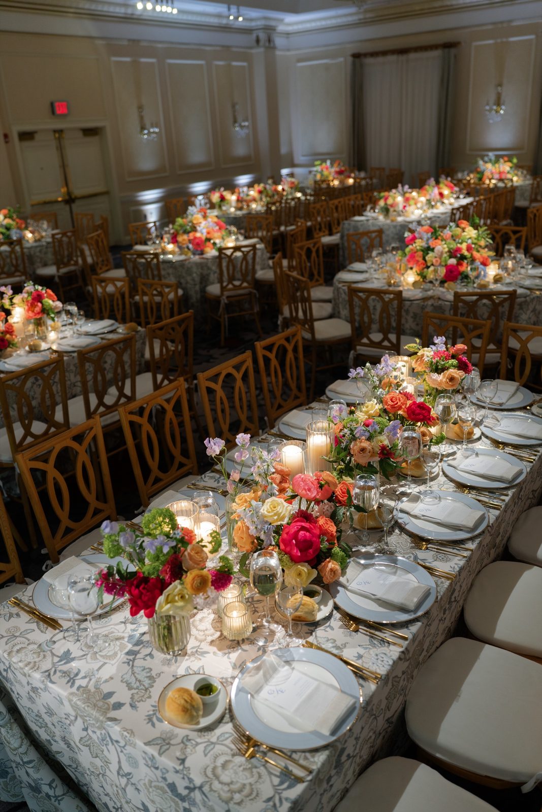 A long table set with orange and red florals