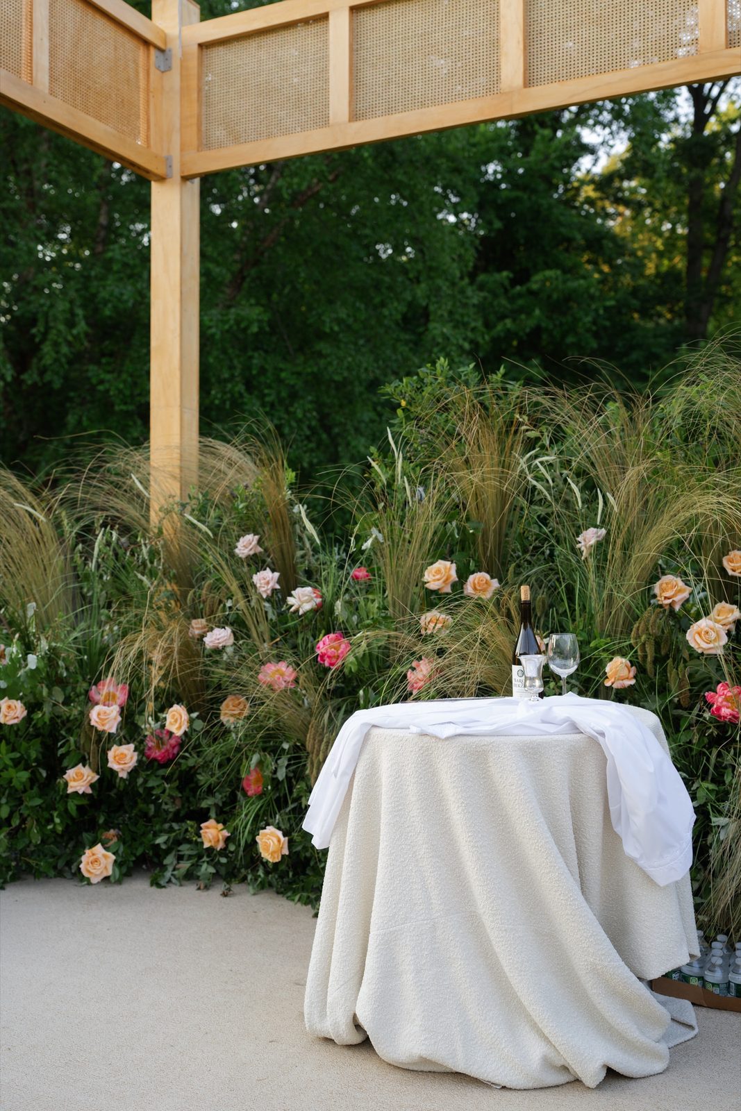 The wooden chuppah set in the garden among flowers