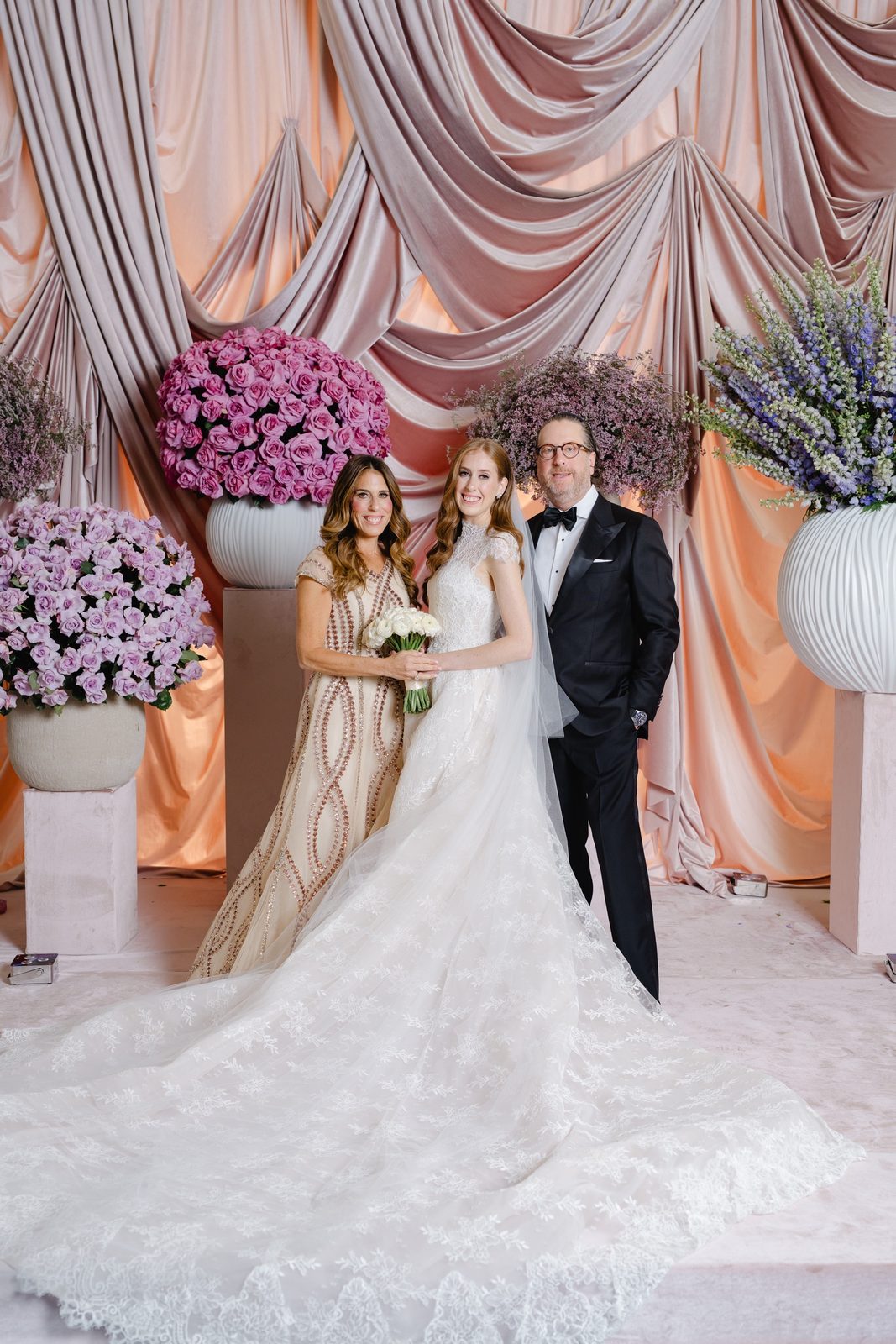 Haley and Evan in front of blush drapes and purple hydrangeas