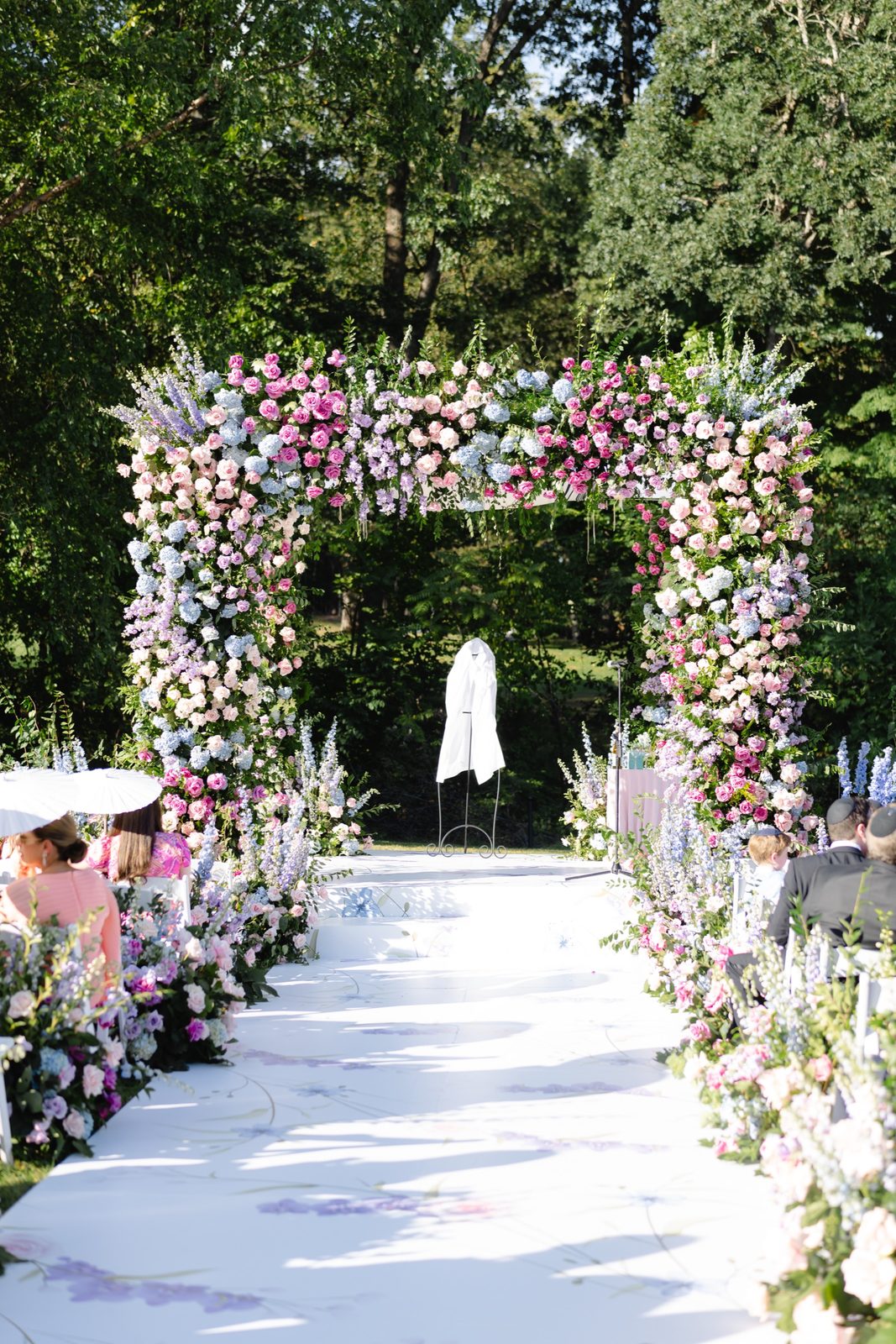 The aisle leading to the pink and purple floral chuppah