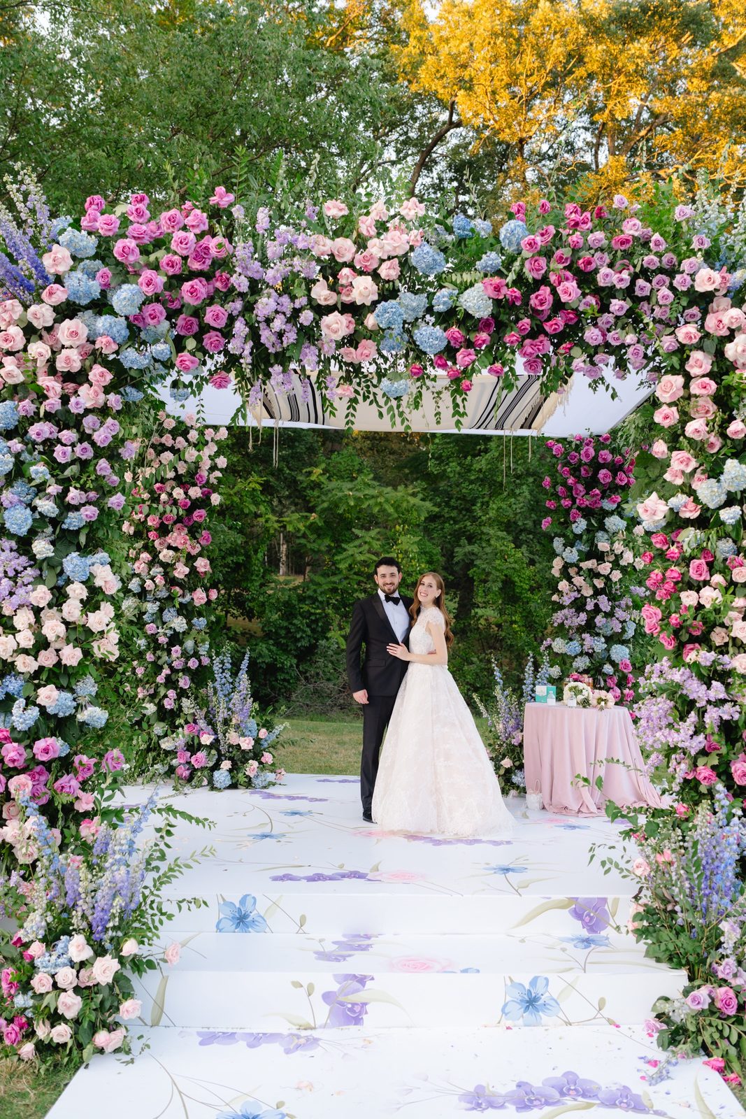 Haley and Evan under the floral arch with early fall color
