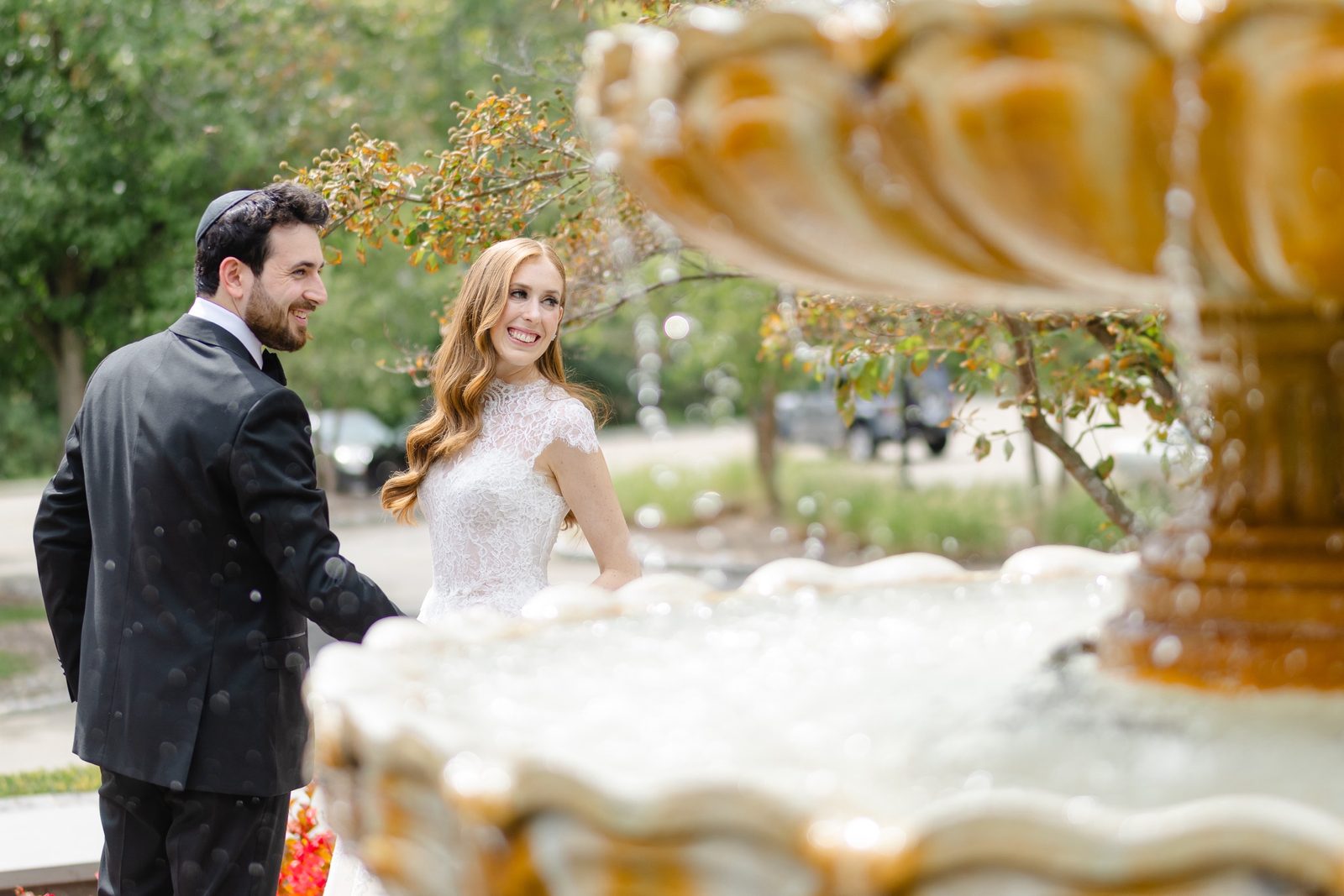 The couple framed through the gold fountain