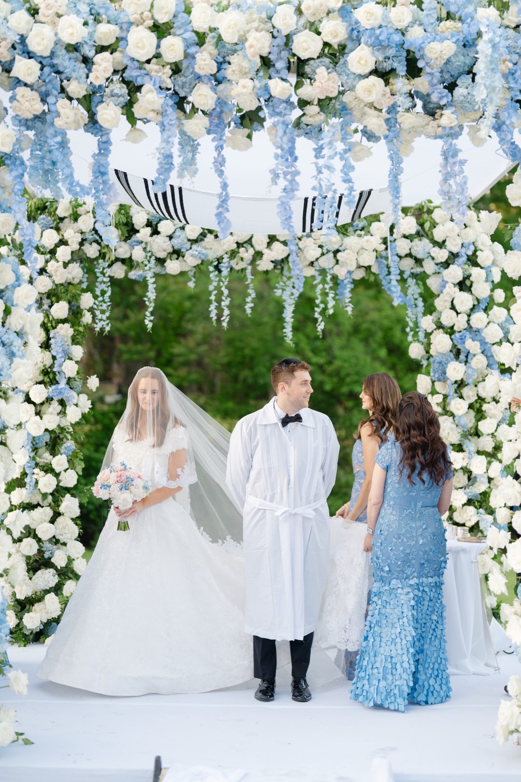 Olivia and Jeremy under the blue and white floral chuppah