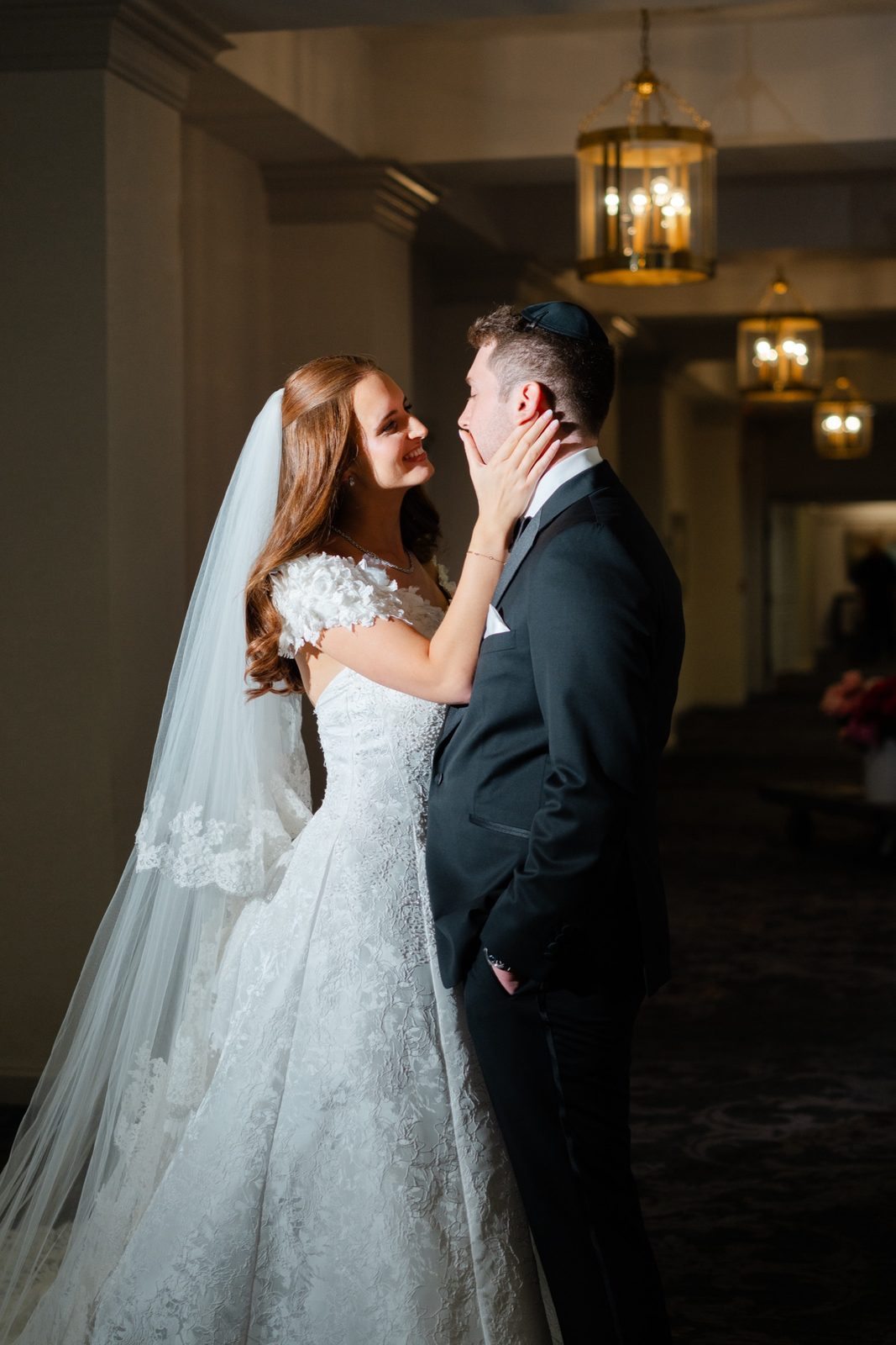 Olivia and Jeremy in the chandelier-lit hallway