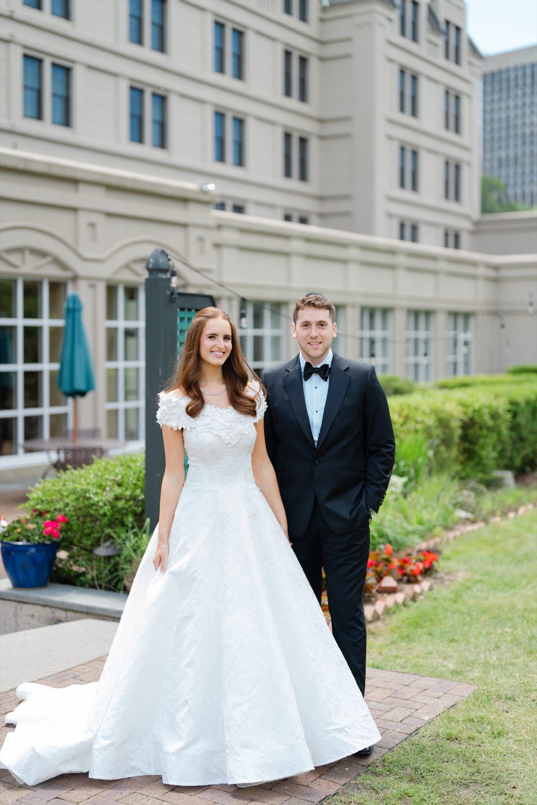 Olivia and Jeremy on the lawn in front of the hotel’s château facade