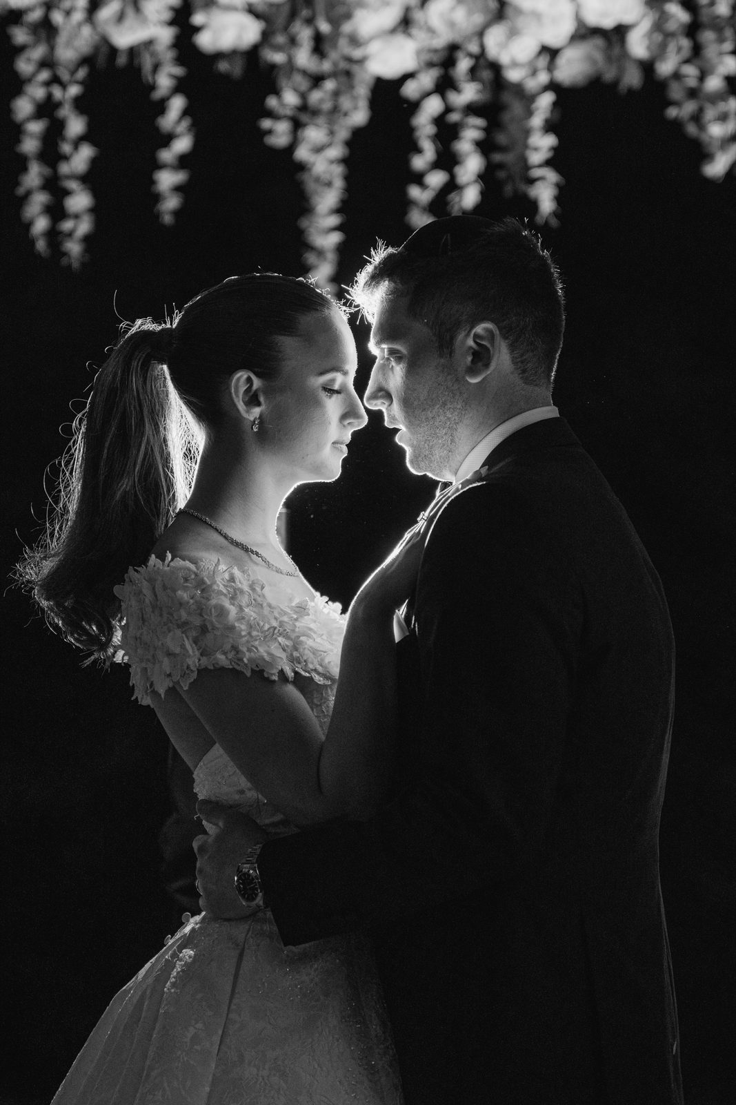 Black and white silhouette of the couple under the chuppah at night