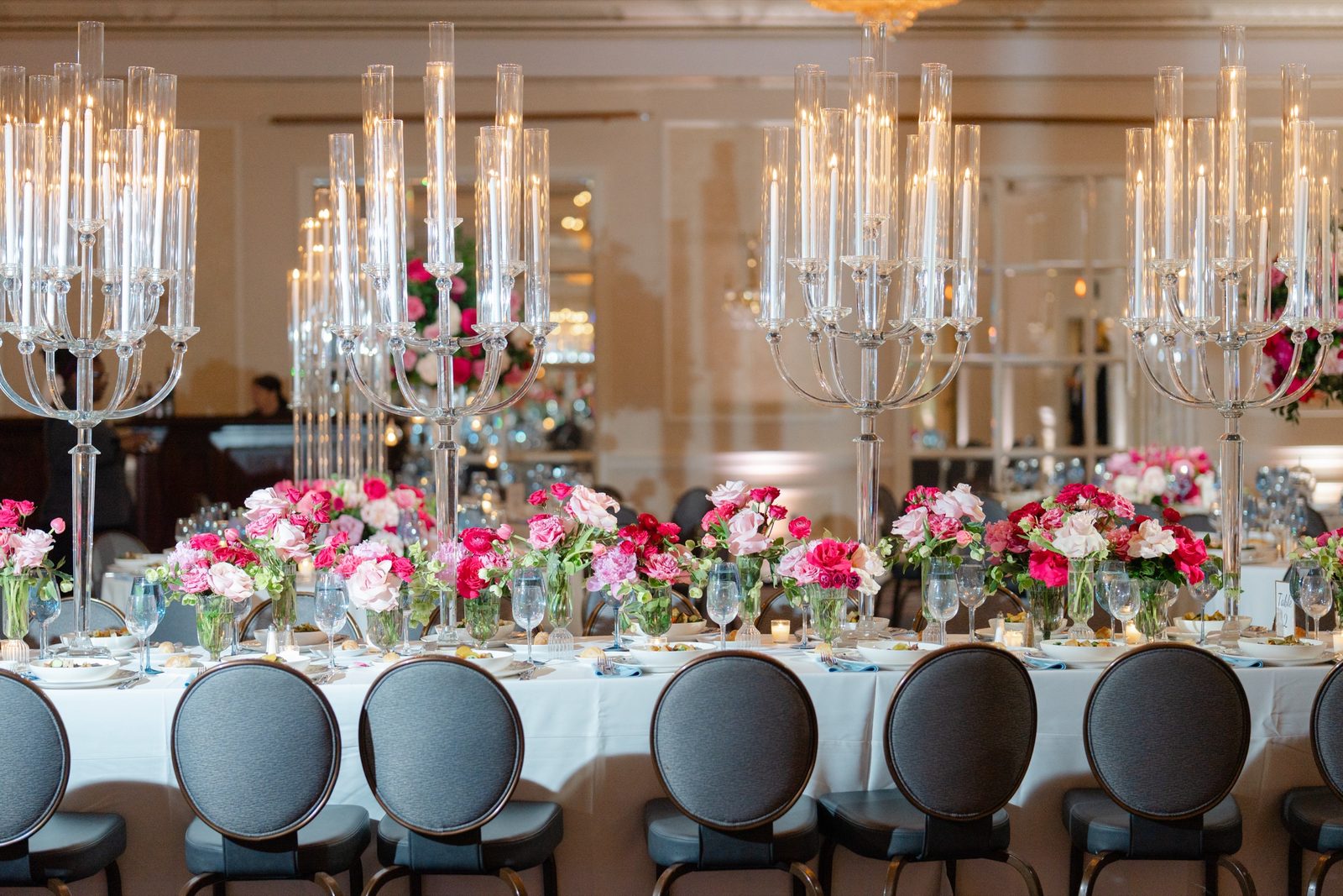 The ballroom set with tall crystal candelabras and pink and red flowers