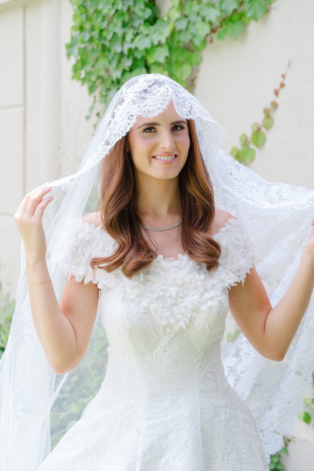 Olivia framing her face with her veil