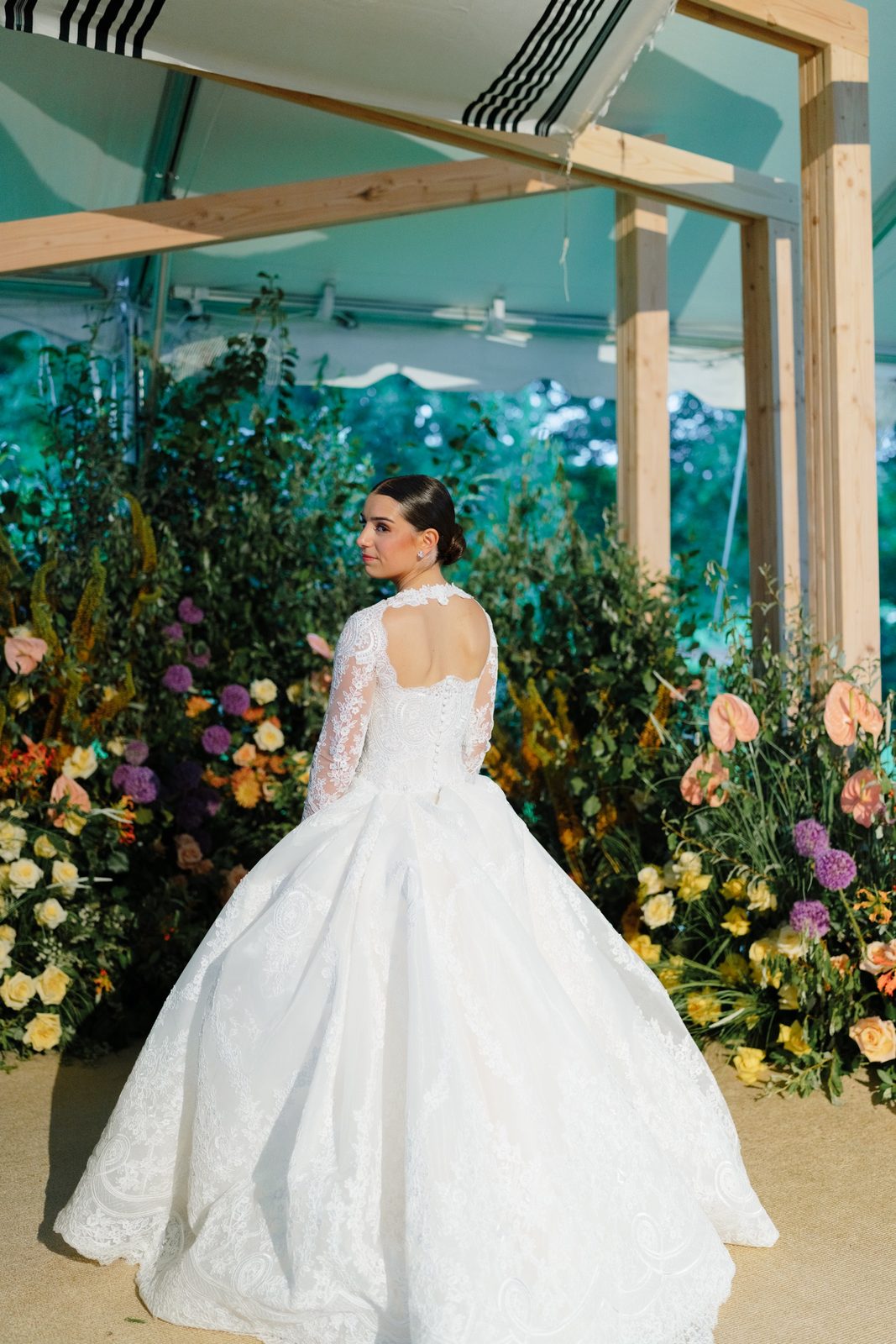 Tommi at the greenery-covered chuppah under the tent