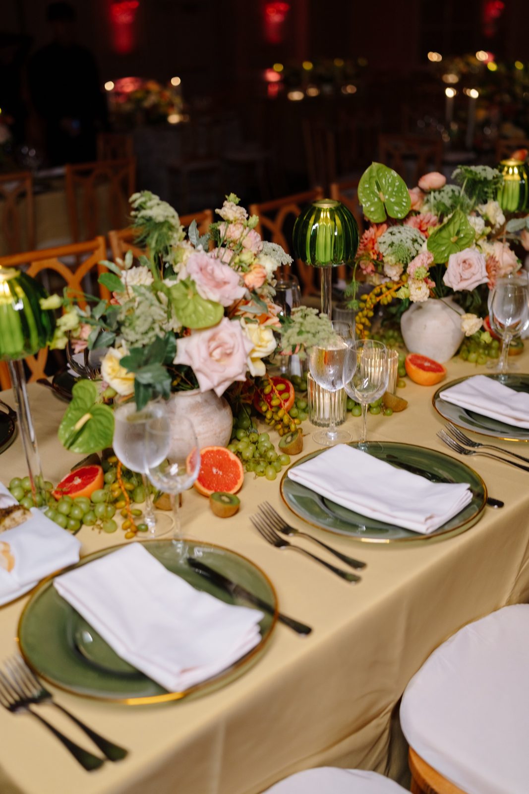 A table set with citrus, florals and green plates