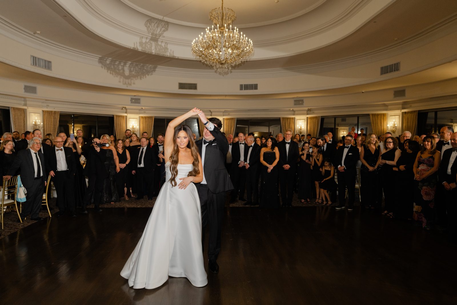 Rachel and Ian's first dance in the ballroom at Oheka Castle, under the chandelier