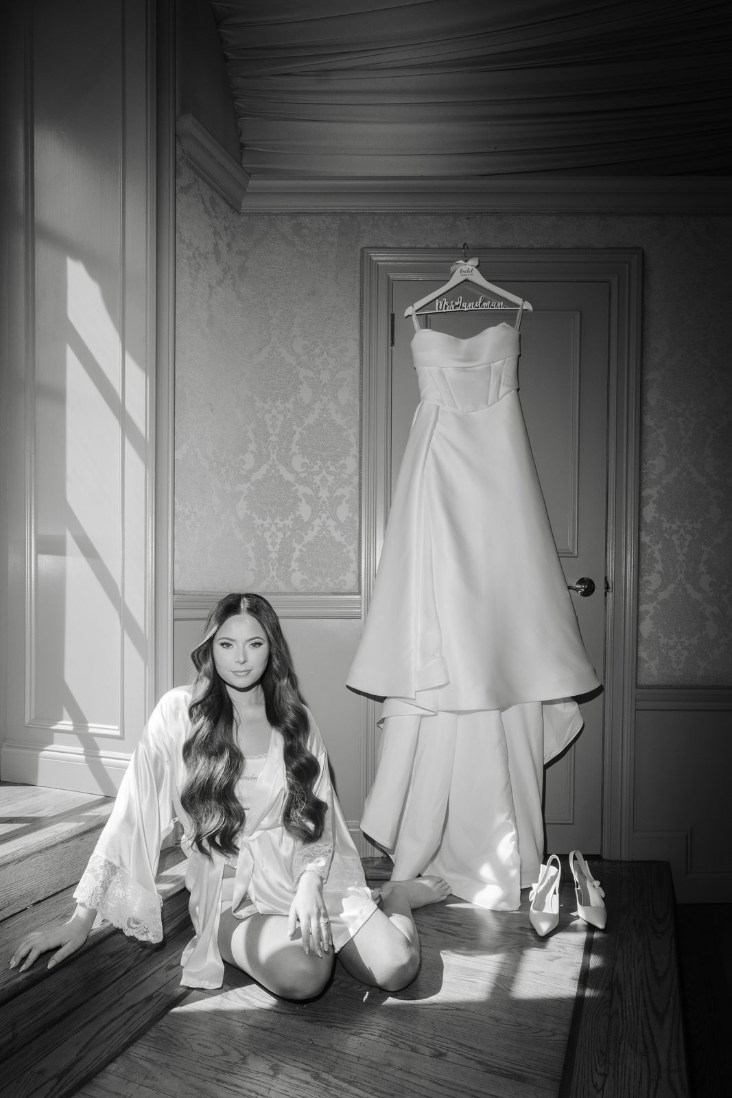 Rachel with her gown hanging in the bridal suite at Oheka Castle