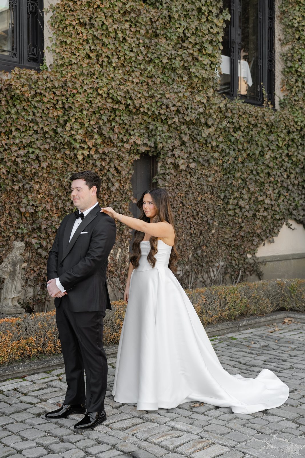 Rachel and Ian's first look against the ivy-covered wall at Oheka Castle