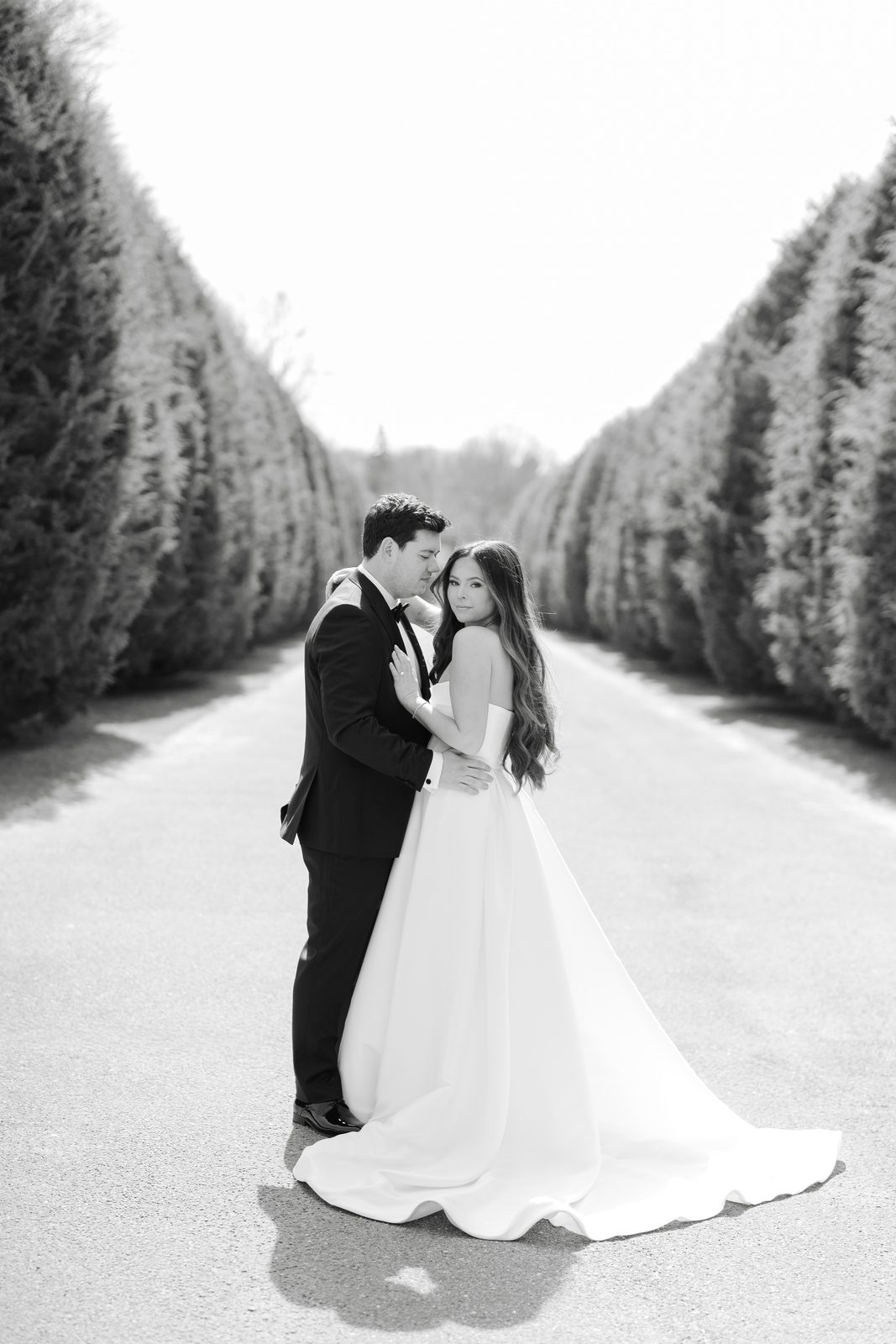 A kiss on the garden allée at Oheka Castle in black and white
