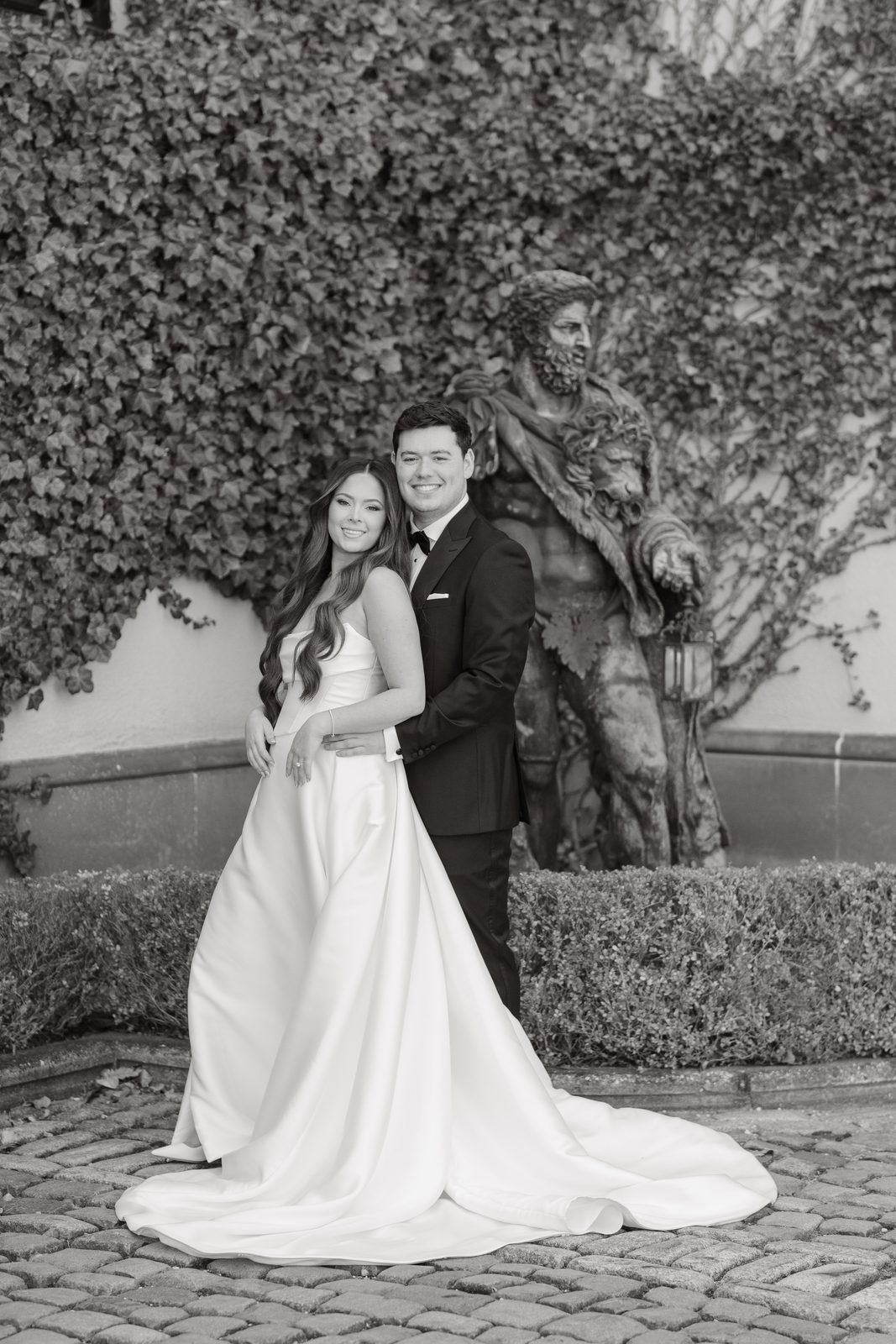 Rachel and Ian against the ivy wall at Oheka Castle, in black and white