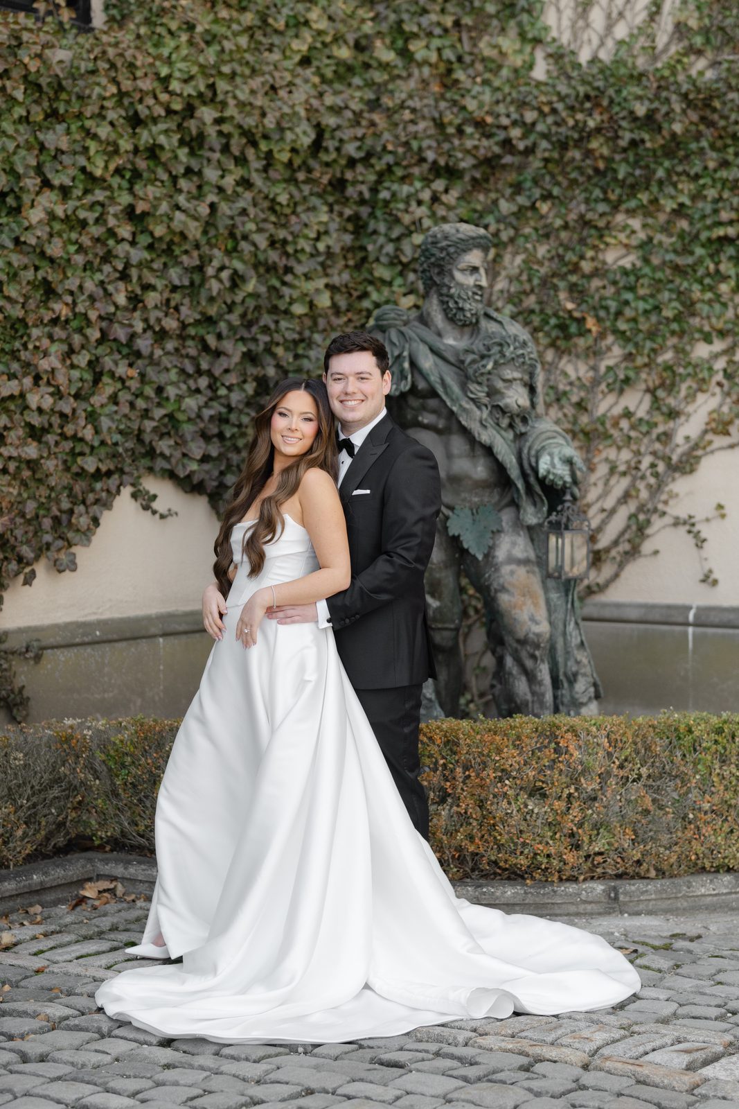 Rachel and Ian beside the bronze statue in the courtyard at Oheka Castle