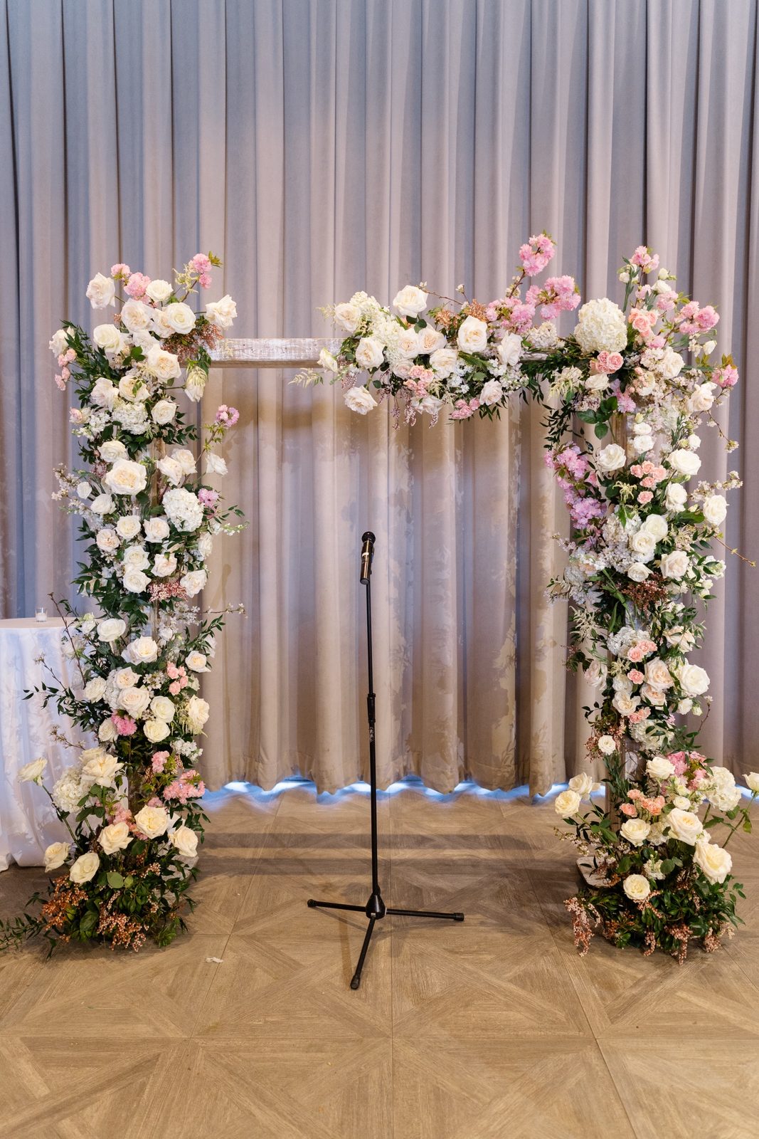 The floral arch of white and pink roses set for the ceremony