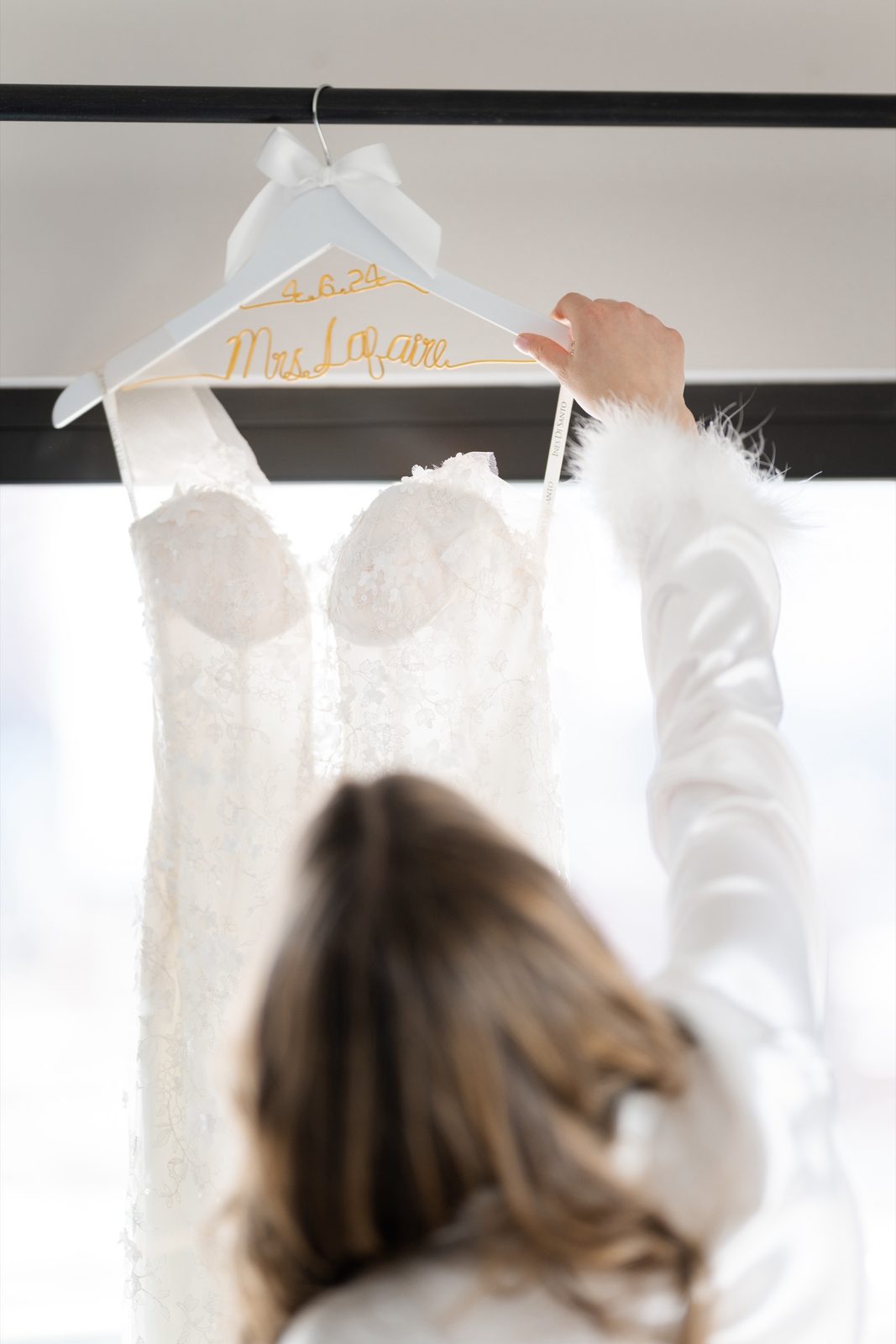 Amanda reaching for her gown on its hanger